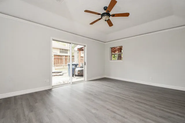 an empty room with wooden floor closet and ceiling fan