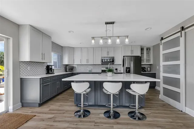 a kitchen with a dining table chairs refrigerator and cabinets