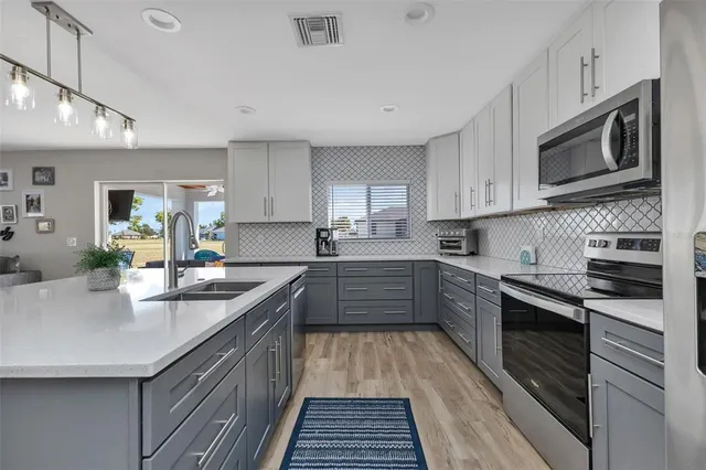 a kitchen with stainless steel appliances granite countertop a sink and stove top oven
