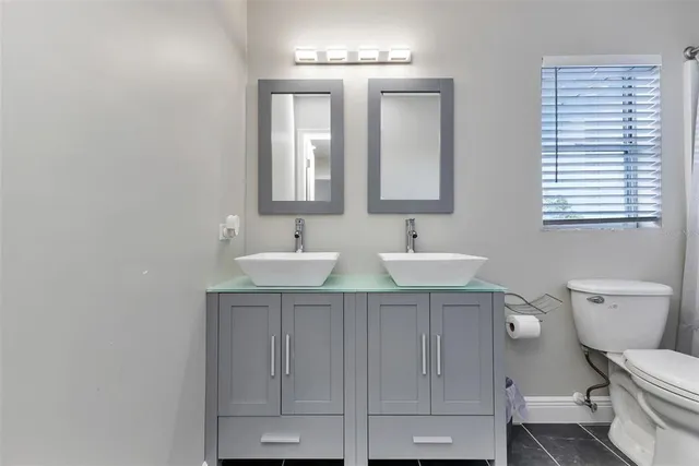a bathroom with a toilet a sink and mirror
