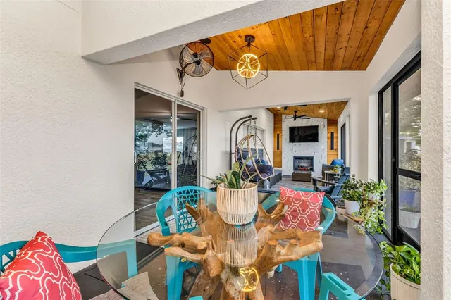 a view of a dining room with furniture one side kitchen view and wooden floor