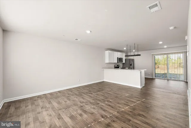 a view of a kitchen with wooden floor and windows