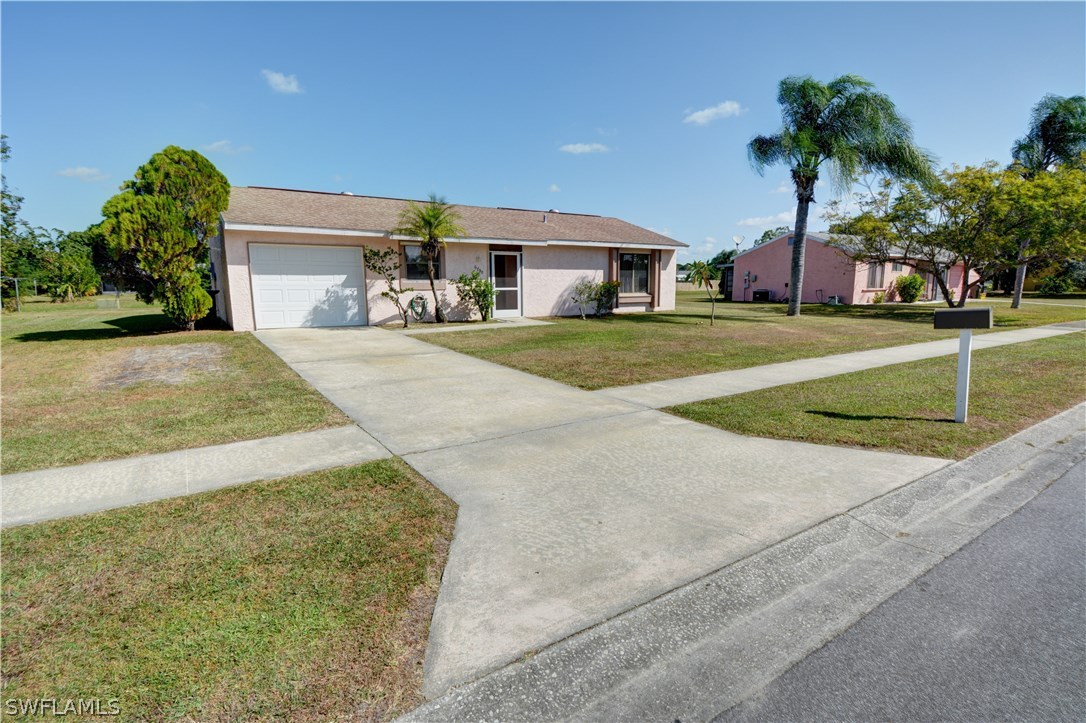 6790 Harmony Road North Port, FL 34287 - Photo 2 of 20 a front view of a house with a yard and garage