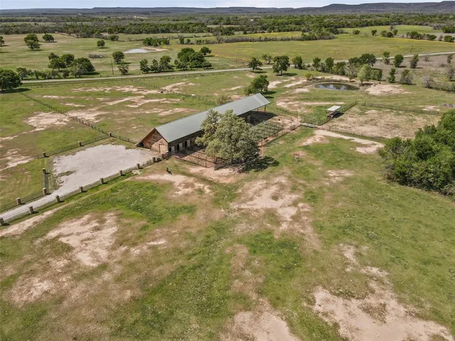 an aerial view of a house with a yard and lake view