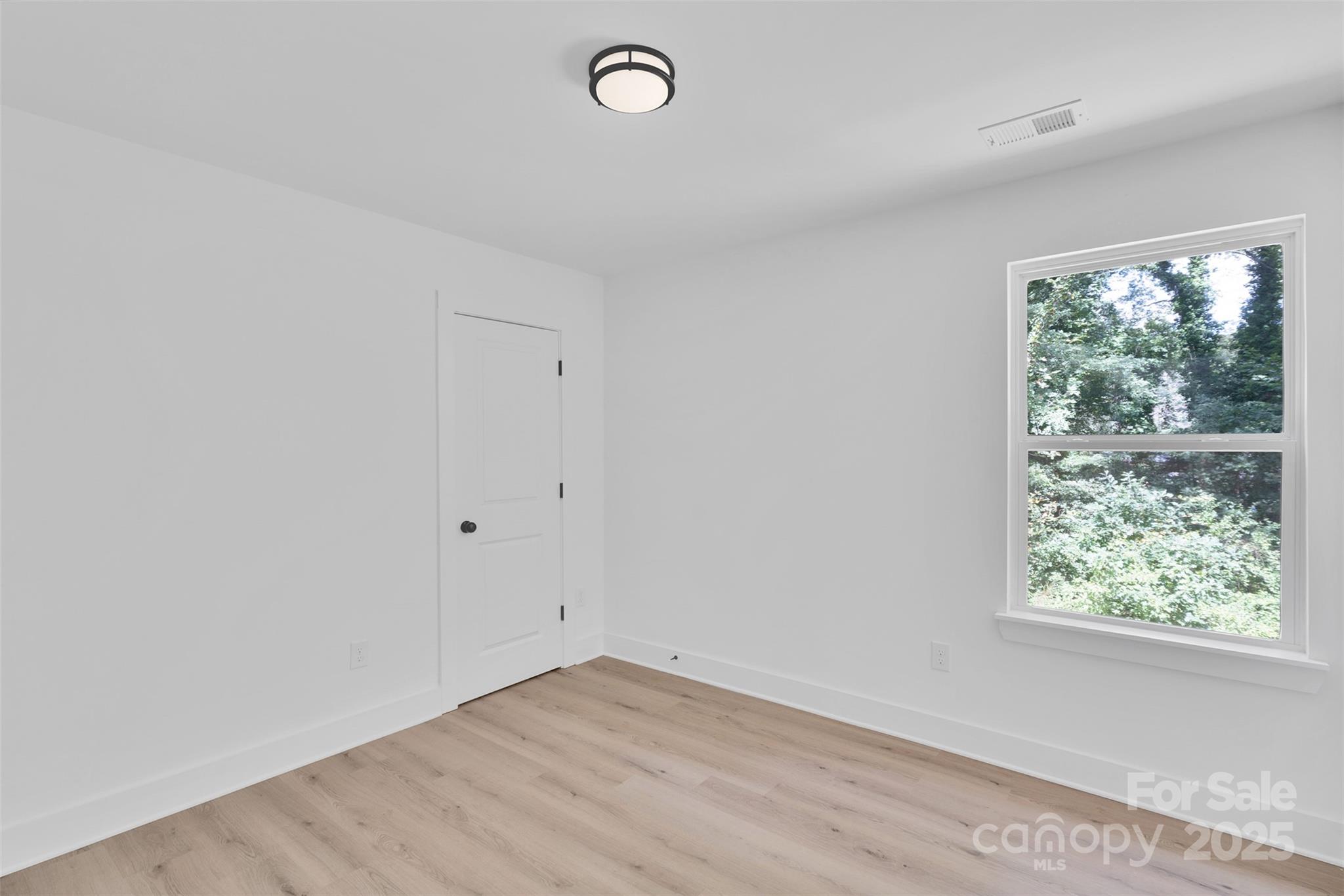 3549 Lake Road Charlotte, NC 28269 - Photo 24 of 34 an empty room with wooden floor and windows