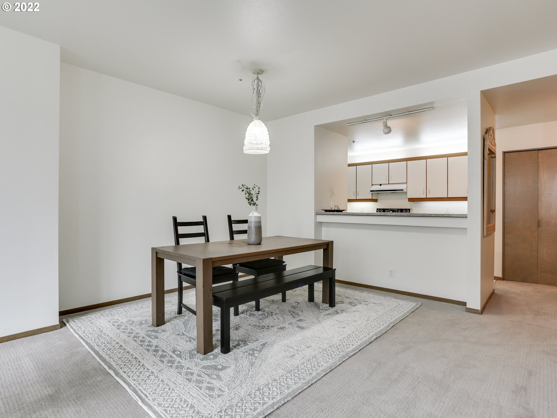 1730 South Harbor Way, Unit 405 Portland, OR 97201 - Photo 12 of 32 a kitchen with a sink dishwasher a dining table and chairs with wooden floor