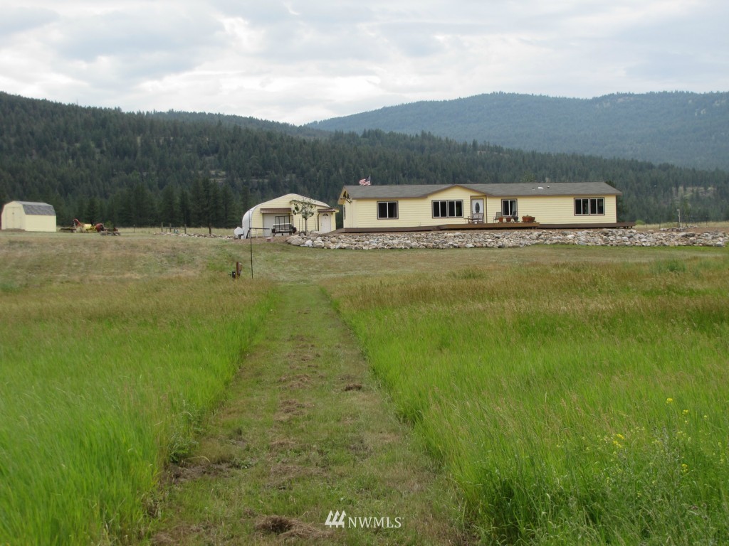 29 Duck Flat Road Tonasket, WA 98855 - Photo 3 of 18 a front view of a house with a garden
