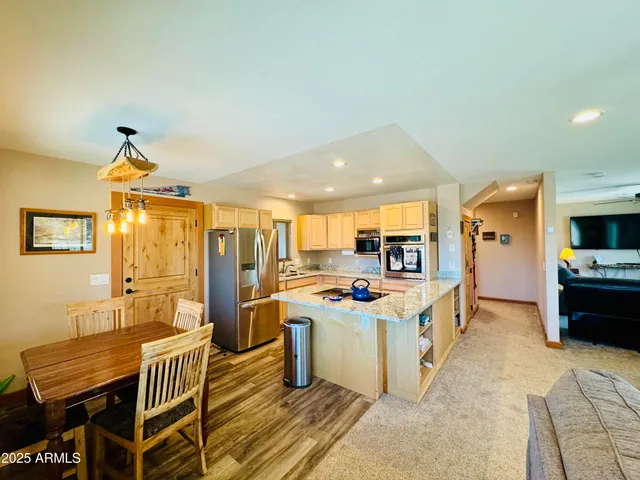 a kitchen with a stove a refrigerator and a dining table