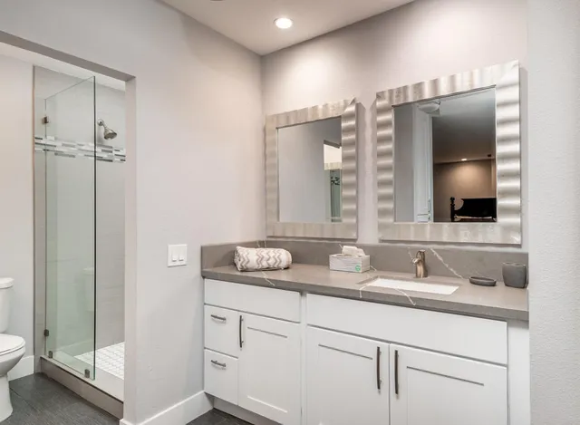 a bathroom with a granite countertop sink and a mirror