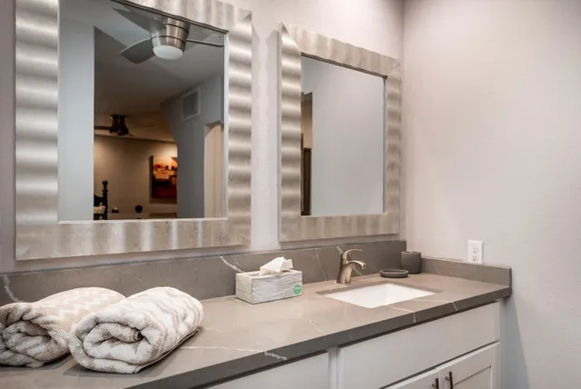 a bathroom with a granite countertop sink and a mirror