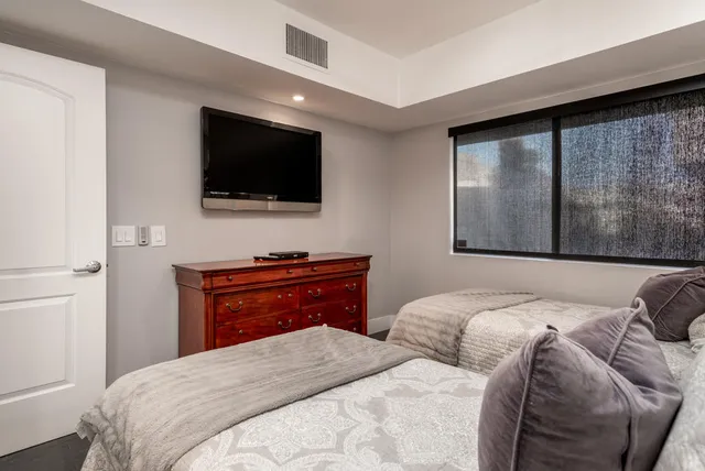 a bedroom with a large bed and a flat screen tv