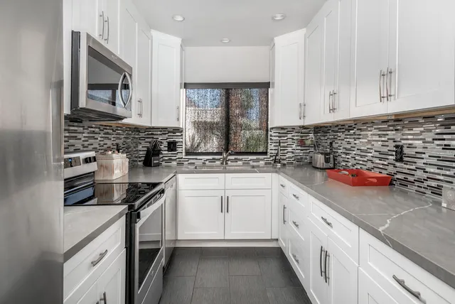 a kitchen with stainless steel appliances a sink stove and cabinets