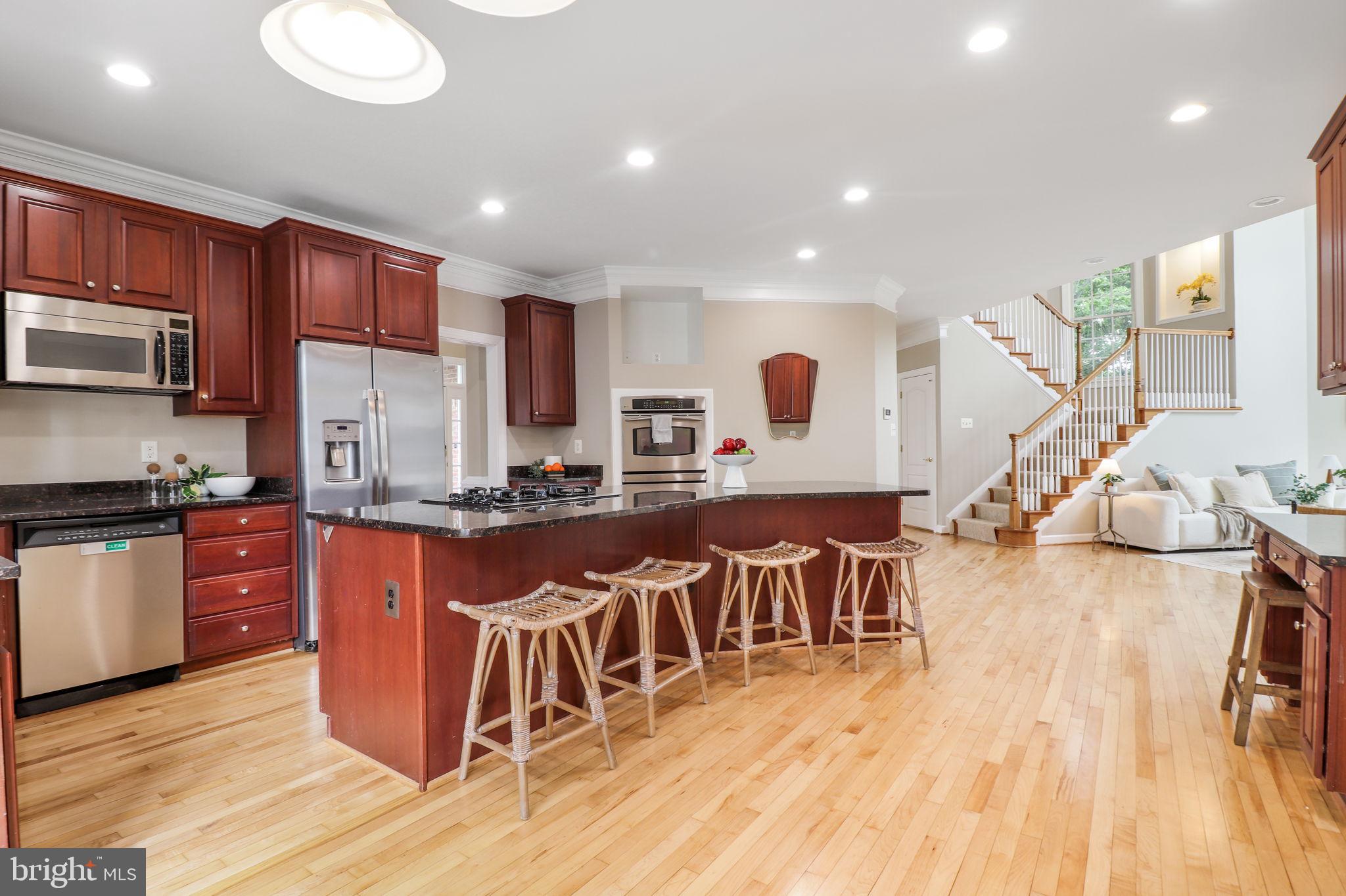 710 Crisfield Way Annapolis, MD 21401 - Photo 11 of 80 a large kitchen with stainless steel appliances lots of counter space and a wooden floor