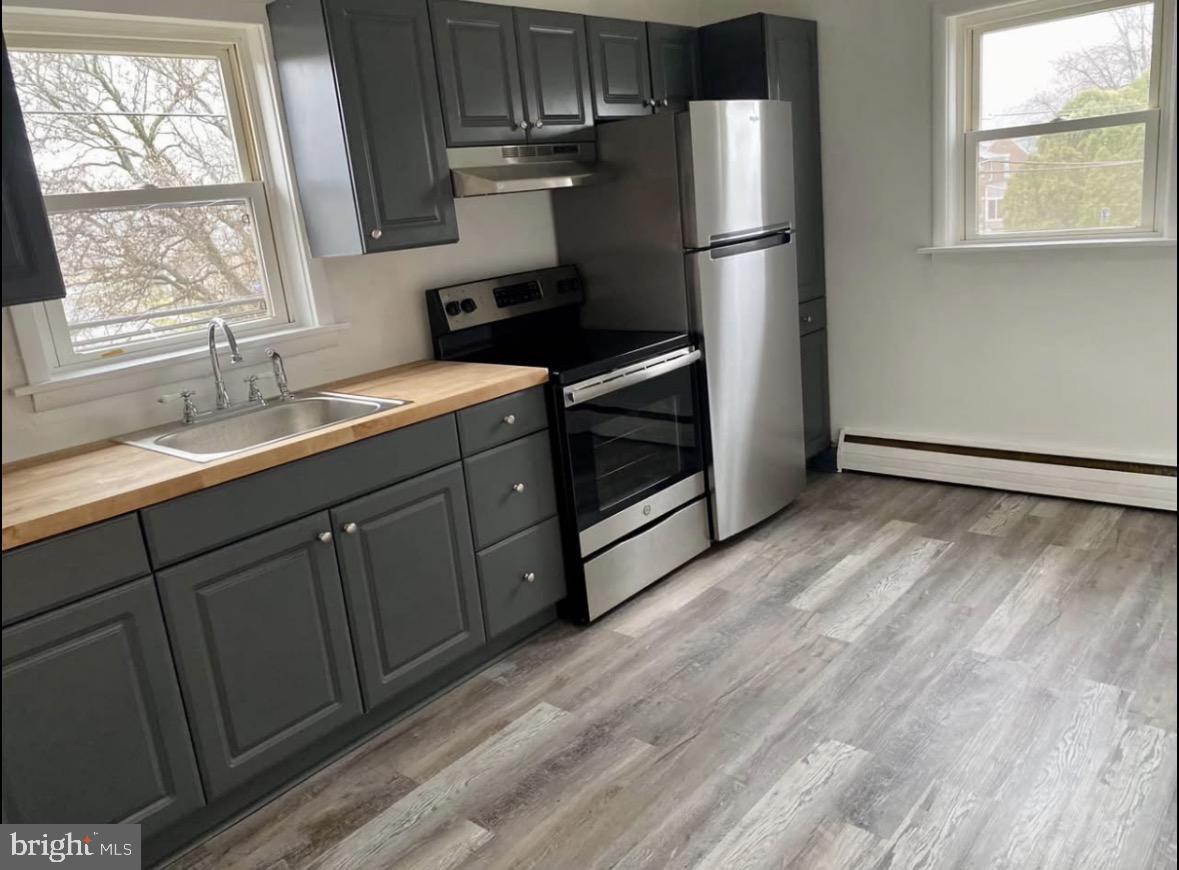 672 Colwell Road Woodlyn, PA 19094 - Photo 2 of 5 a kitchen with stainless steel appliances granite countertop a refrigerator sink and wooden cabinets