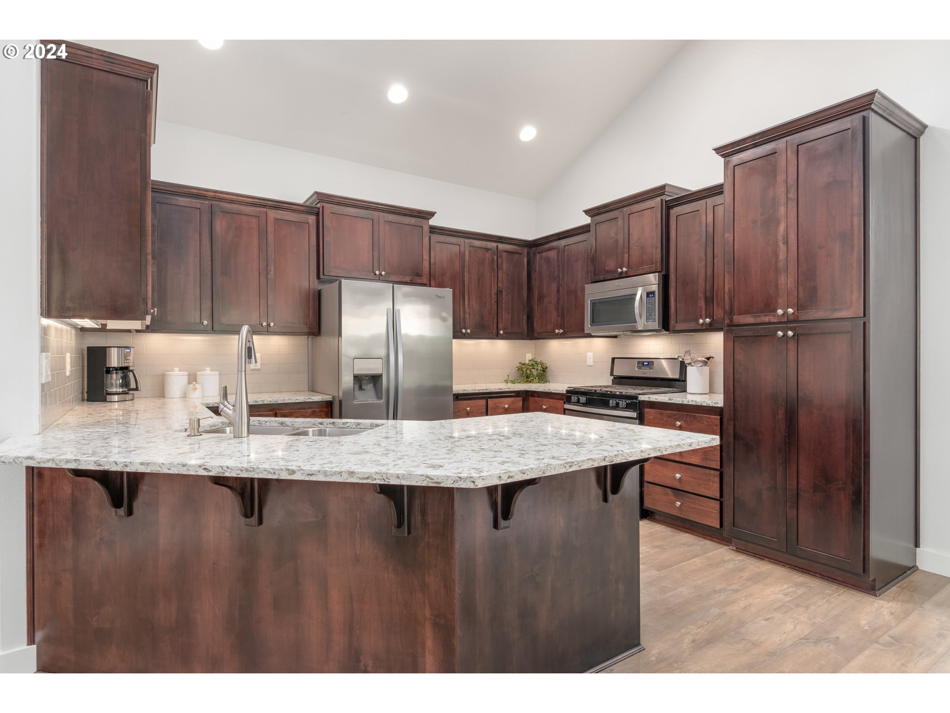 3622 Stark Street Eugene, OR 97404 - Photo 9 of 48 a kitchen with stainless steel appliances granite countertop a refrigerator a sink a stove a microwave and wooden cabinets