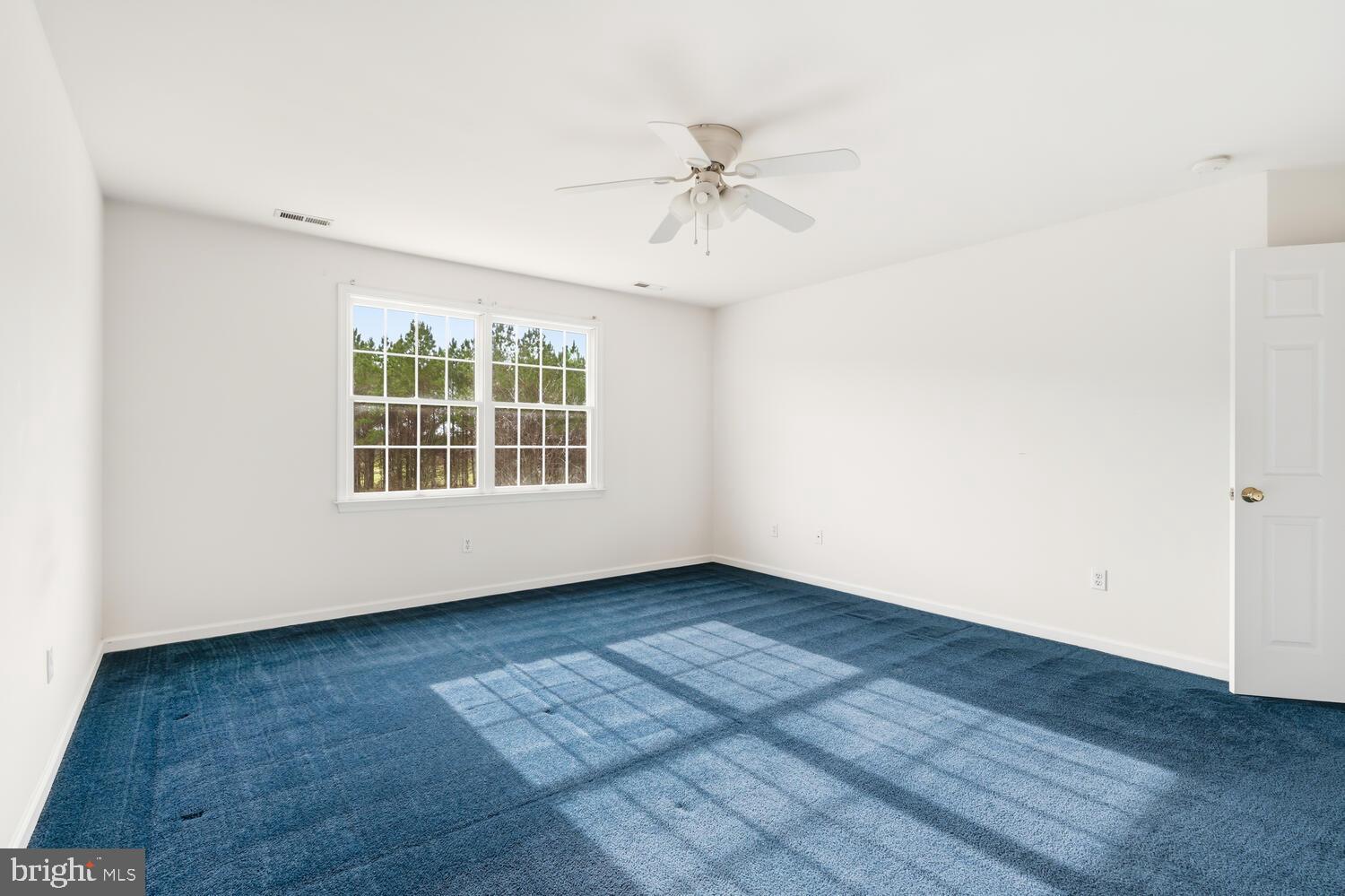 30224 Chestnut Ridge Lane Trappe, MD 21673 - Photo 36 of 46 an empty room with wooden floor chandelier fan and windows