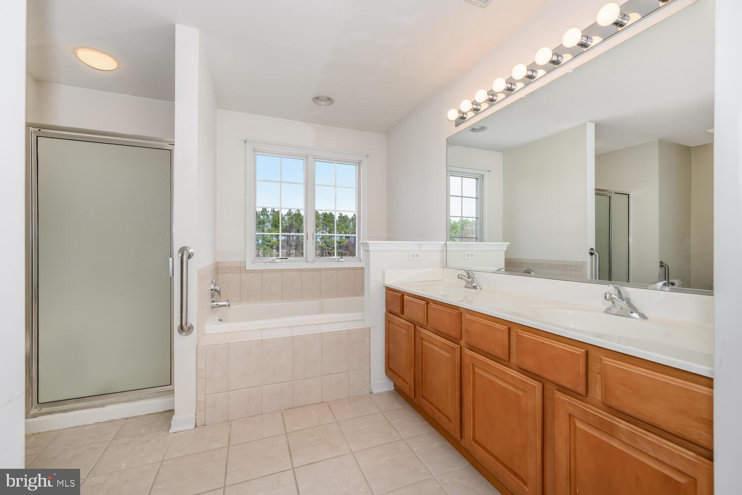 30224 Chestnut Ridge Lane Trappe, MD 21673 - Photo 38 of 46 a spacious bathroom with a double vanity sink a mirror and a bathtub