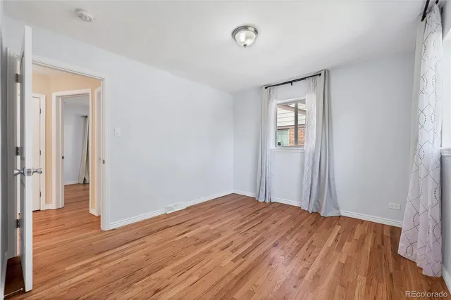 a view of empty room with wooden floor