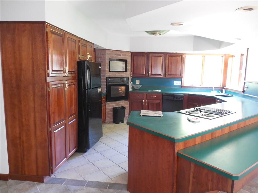 249 West Lake Road Transfer, PA 16154 - Photo 4 of 19 This cherry kitchen has amply counter space, recessed lighting and a bar and a built in oven and dishwasher.