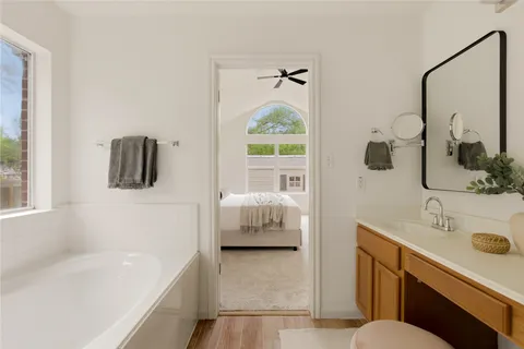 a bathroom with a bathtub sink and mirror