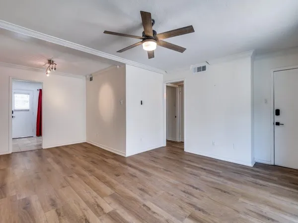 a view of an empty room with wooden floor