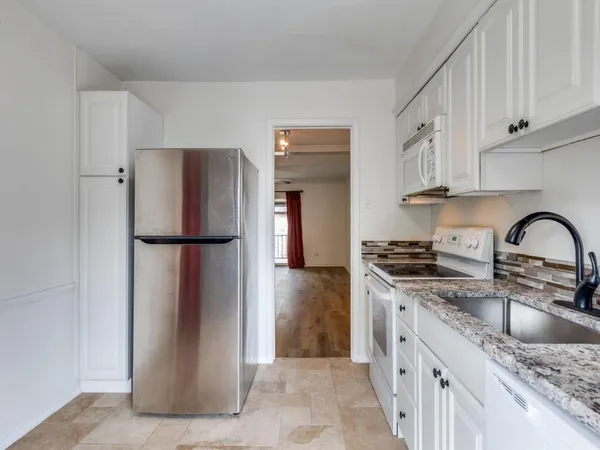 a kitchen with stainless steel appliances granite countertop a refrigerator and a sink