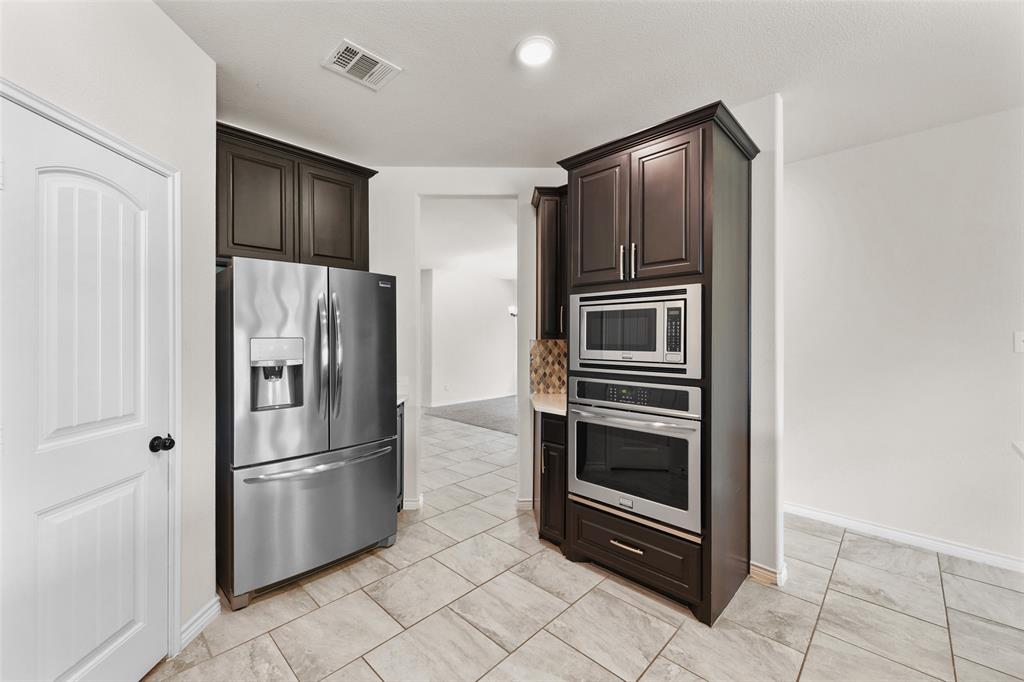 3031 Lily Lane Forney, TX 75126 - Photo 11 of 28 a metallic refrigerator freezer and a refrigerator in a kitchen