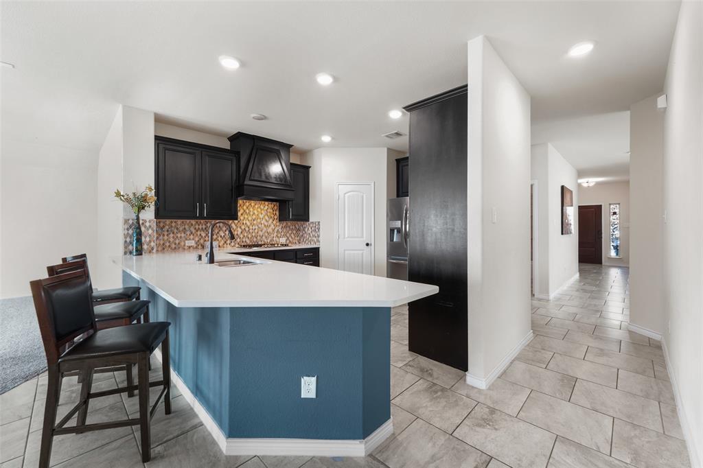 3031 Lily Lane Forney, TX 75126 - Photo 12 of 28 a kitchen with stainless steel appliances kitchen island granite countertop a refrigerator a stove and a sink