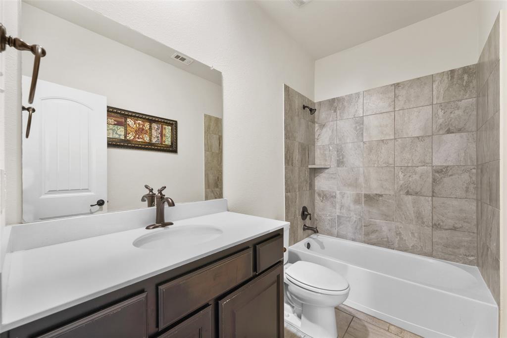 3031 Lily Lane Forney, TX 75126 - Photo 19 of 28 a bathroom with a sink a toilet and a bathtub