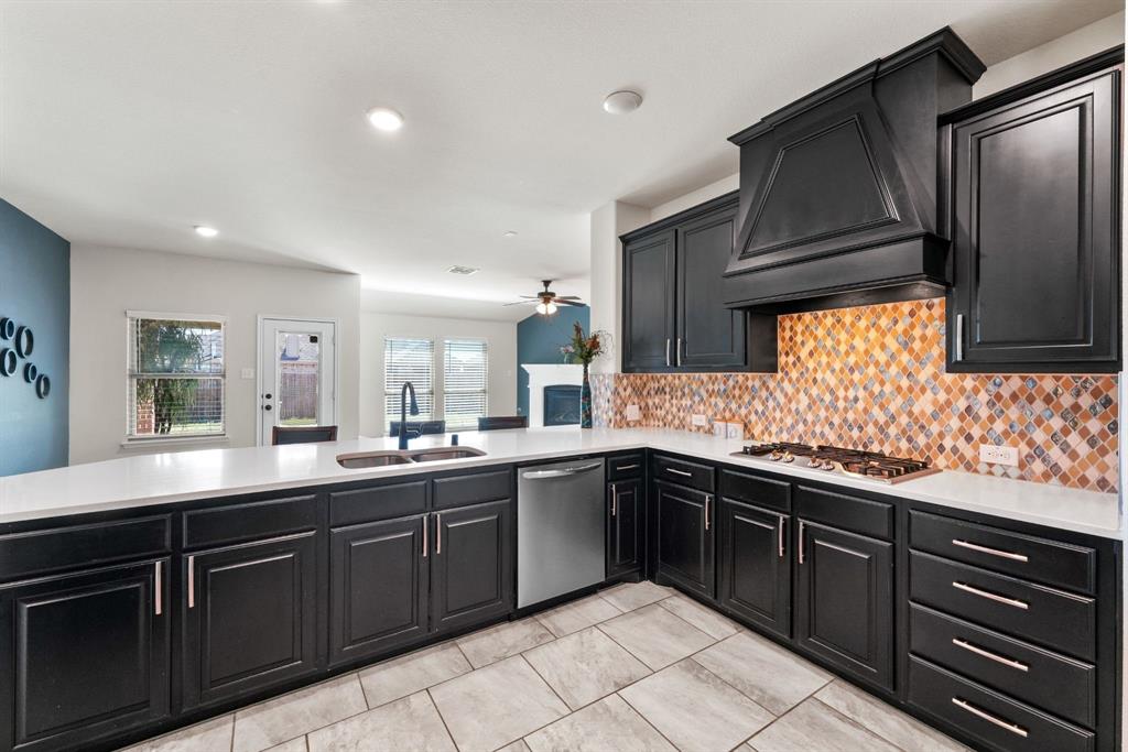 3031 Lily Lane Forney, TX 75126 - Photo 3 of 28 a kitchen with granite countertop stainless steel appliances a sink and cabinets