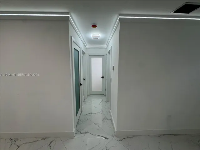 a view of hallway with closet and a bathroom
