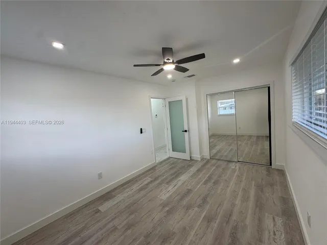 a view of empty room with window and ceiling fan