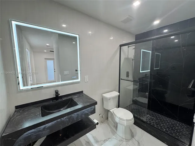 a bathroom with a toilet a sink and mirror