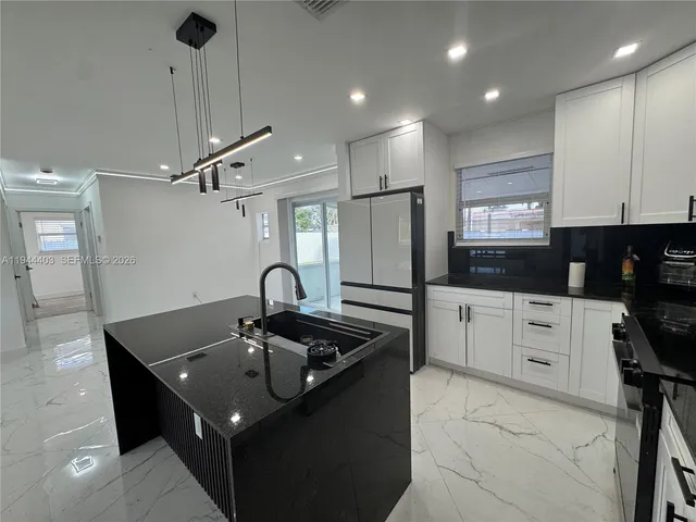 a kitchen with kitchen island stainless steel appliances a sink stove and refrigerator