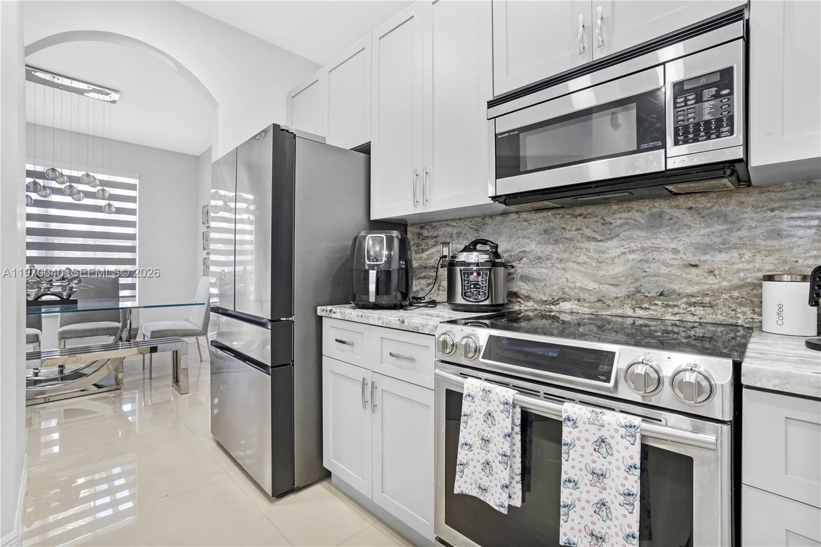 2132 Northeast 38th Road Homestead, FL 33033 - Photo 8 of 48 a kitchen with stainless steel appliances white cabinets and a stove top oven