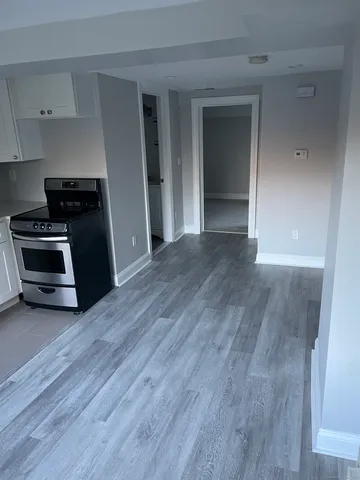 a view of a kitchen with wooden floor and cabinets