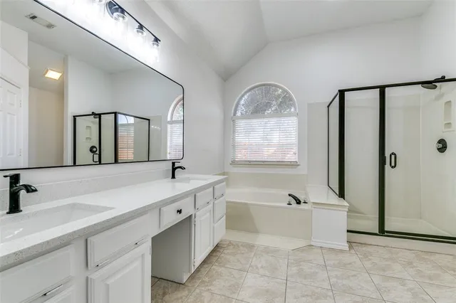 a spacious bathroom with a double vanity sink a mirror and a bathtub