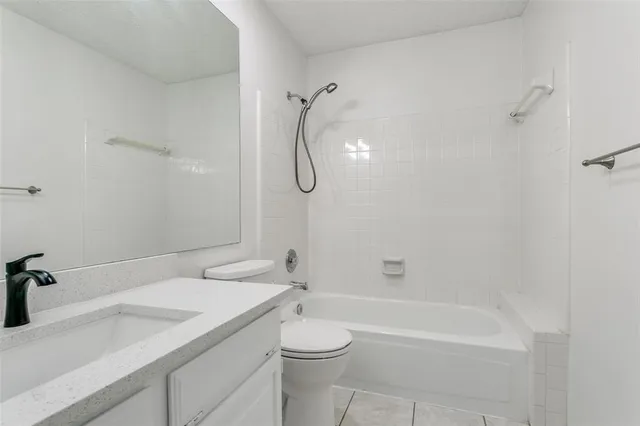 a bathroom with a granite countertop sink a toilet and shower