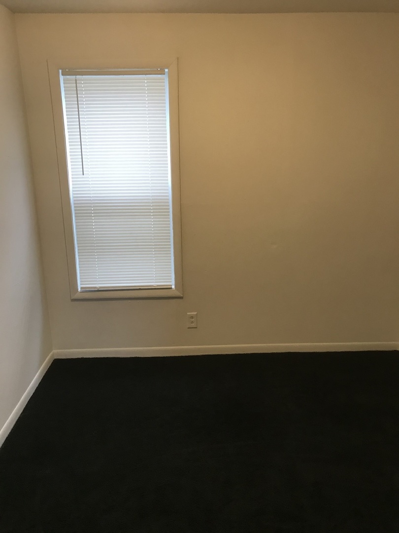 3929 Main Street, Unit 2 McHenry, IL 60050 - Photo 15 of 17 a view of an empty room with wooden floor and a window