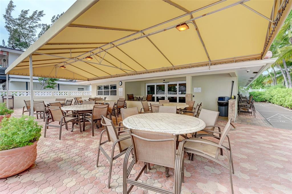 401 Briny Avenue, Unit 409 Pompano Beach, FL 33062 - Photo 46 of 62 a patio with a table and chairs