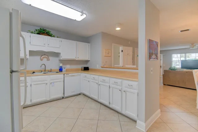a kitchen with white cabinets and white appliances