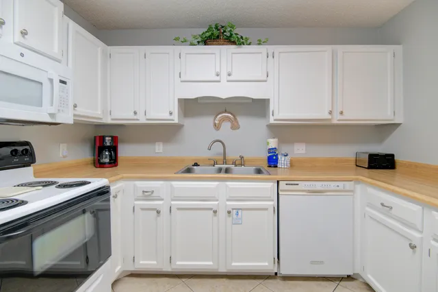 a kitchen with white cabinets and white appliances