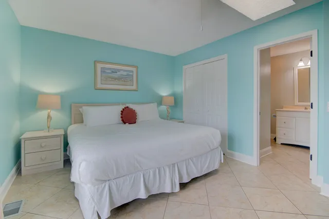 a bedroom with a bed and a lamp on dresser