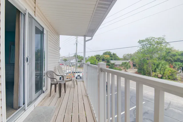 a view of a chairs and table in patio with wooden floor