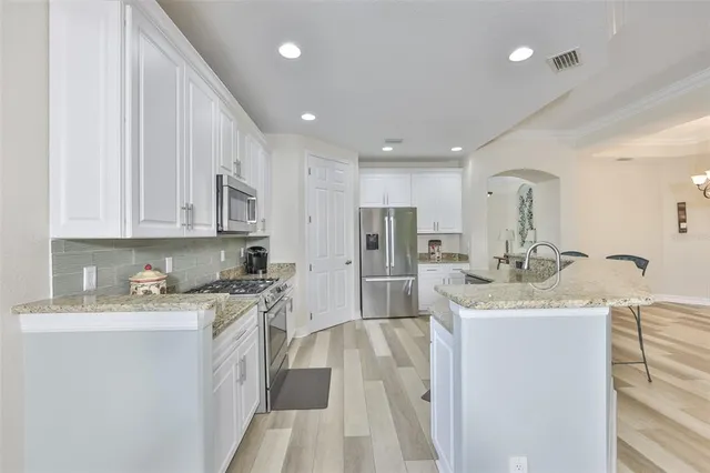 a kitchen with a sink a stove a refrigerator and cabinets