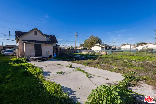 a view of a house with a big yard and potted plants