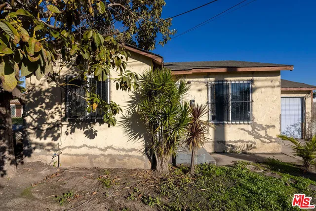 a view of house with backyard and a tree