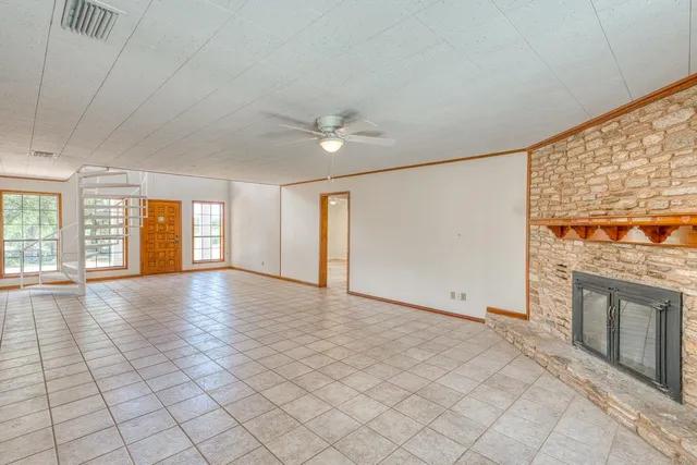 an empty room with windows and fireplace