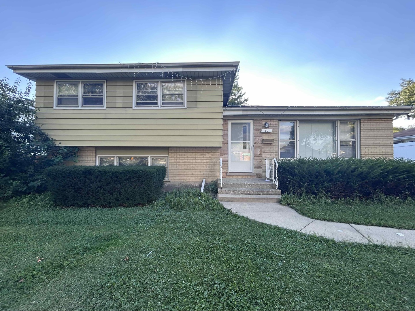 10 Adams Drive Addison, IL 60101 - Photo 1 of 12 a front view of a house with a garden and yard
