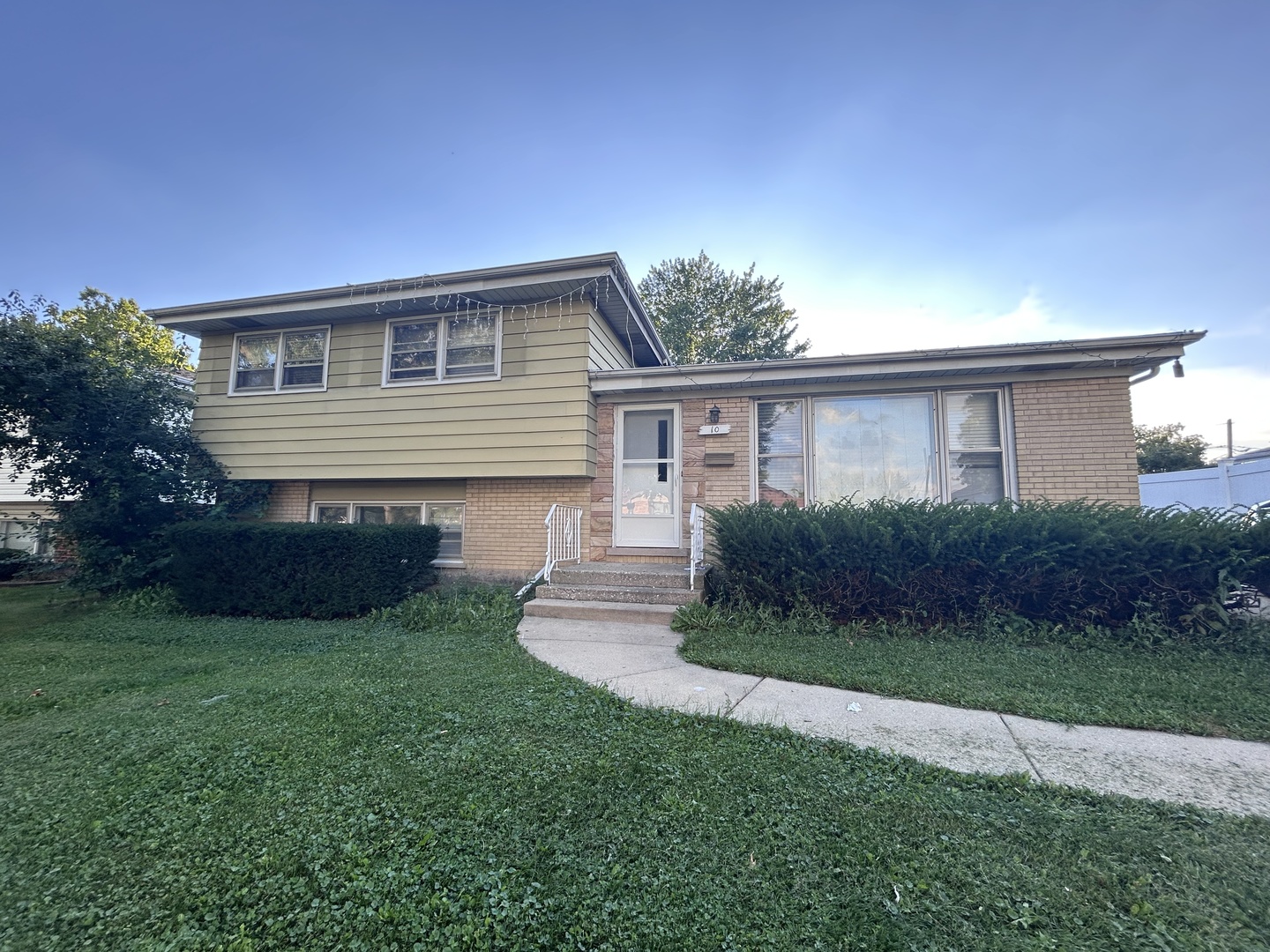 10 Adams Drive Addison, IL 60101 - Photo 2 of 12 a front view of a house with a garden and yard